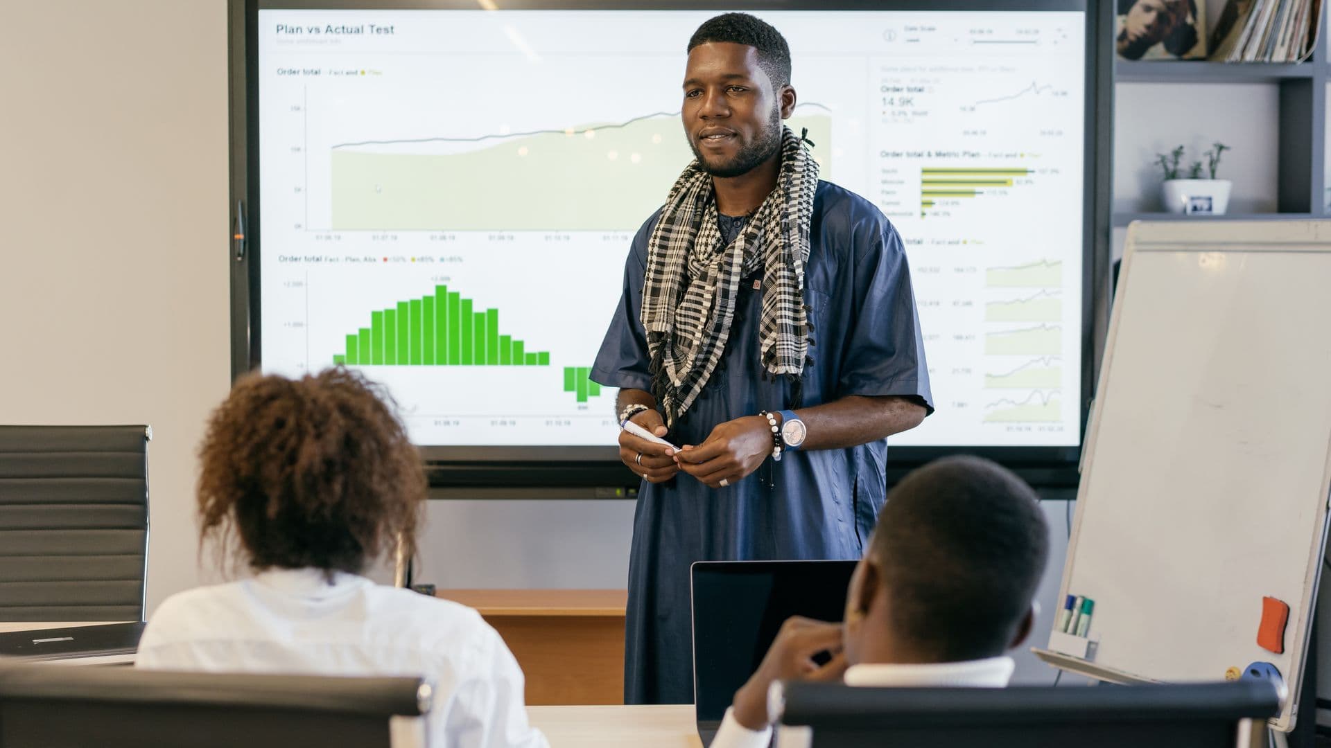 A consultant presenting a performance dashboard to colleagues in a boardroom