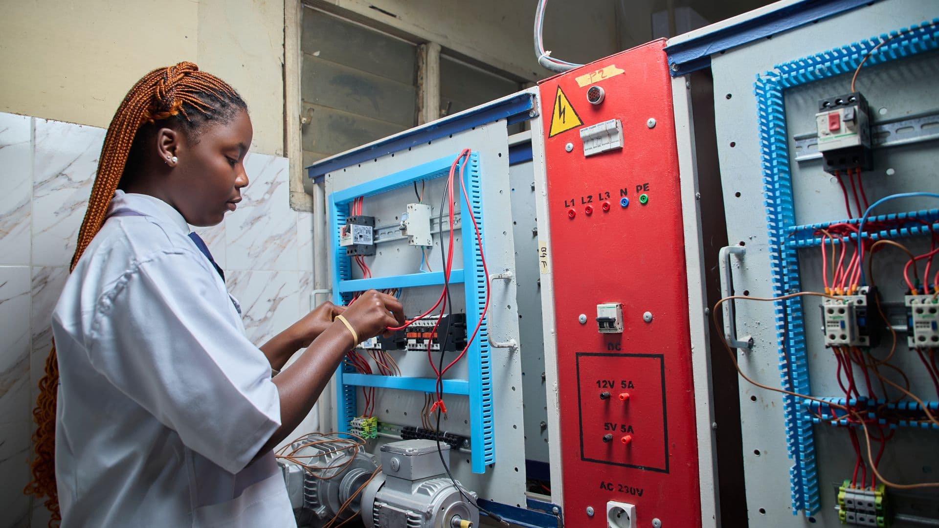 An engineer wiring an electrical control panel on site